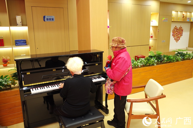 兩位老人邊彈邊唱。人民網(wǎng)記者 覃心攝