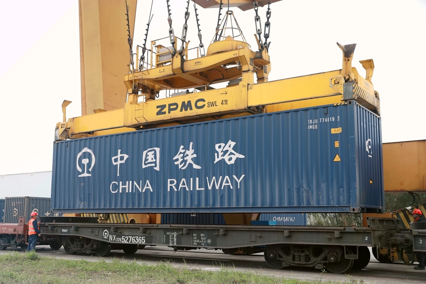 在南寧國際鐵路港內(nèi)，裝卸作業(yè)人員正在有序?qū)⒖缇臣b箱吊裝至火車。譚媛元攝