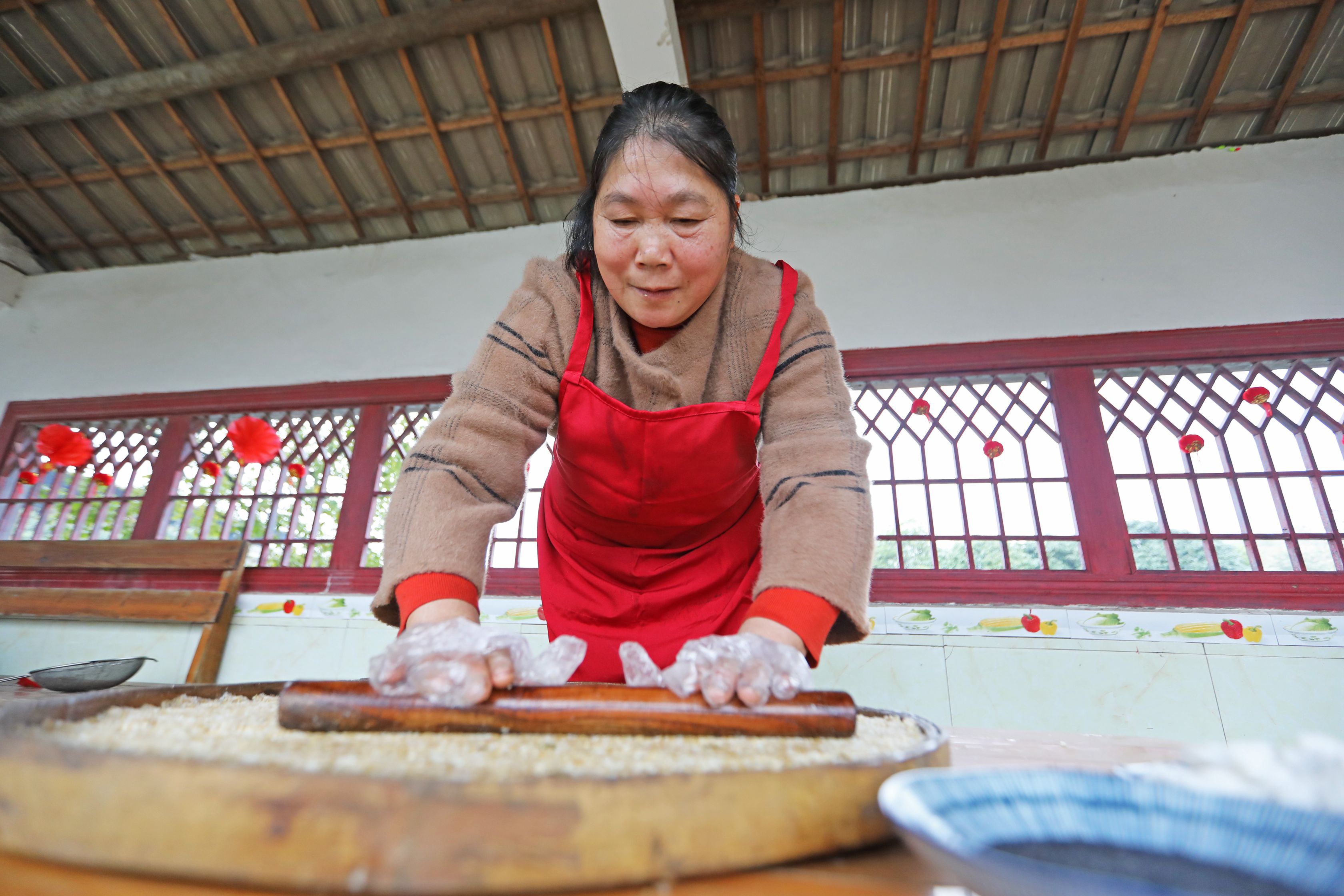 村民用搟面杖把米花糖壓實。陽海翔攝