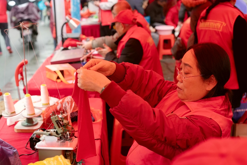 志愿者為居民縫補衣服。蘭炳侶攝