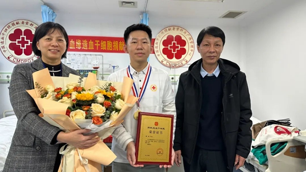 中國造血干細胞捐獻者資料庫廣西管理中心工作人員為譚醫(yī)生（左二）頒發(fā)捐獻榮譽證書和獎?wù)? /></p>
<p style=