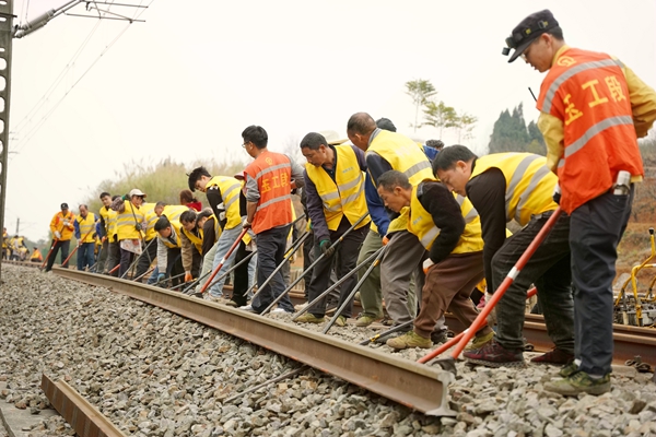職工在線路上利用撬棍奮力進(jìn)行撥軌作業(yè)。王冠杰攝