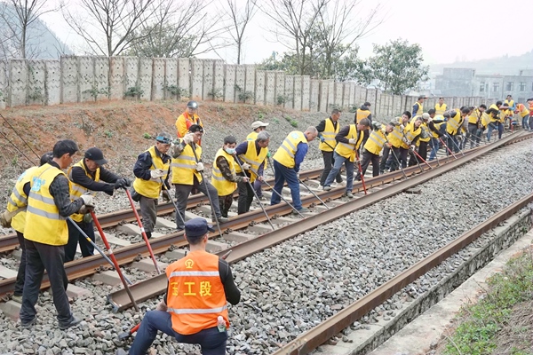 職工合力進(jìn)行線路撥軌作業(yè)。王冠杰攝