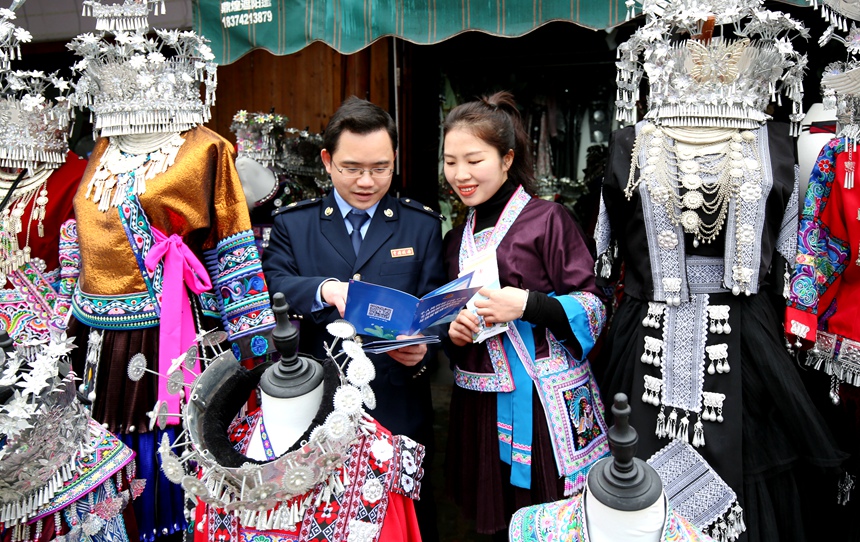 圖為融水苗族自治縣稅務(wù)局稅費(fèi)服務(wù)團(tuán)隊(duì)深入“夢(mèng)嗚苗寨”，開展“稅收宣傳+民俗坡會(huì)”活動(dòng)。 梁新宗攝