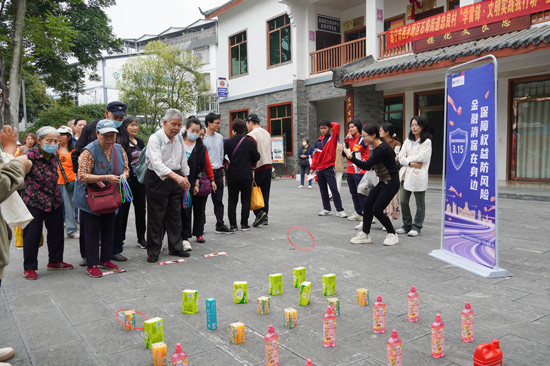 浦發(fā)銀行南寧分行金融知識宣講員通過“消保知識錦囊”獲取套圈權(quán)益等游戲方式引導(dǎo)鄉(xiāng)村民眾們“樂學(xué)”金融知識，防范金融風(fēng)險。（黃曉明攝）