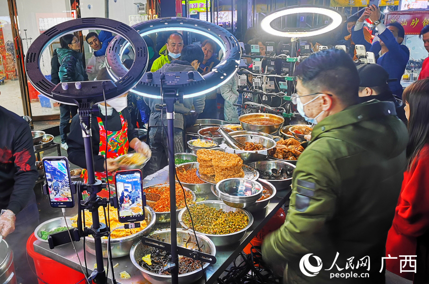 一家螺螄粉攤，攤主一邊直播一邊賣螺螄粉。人民網(wǎng) 付華周攝