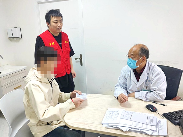 劉華鋒陪同村民的孩子看病。桂林醫(yī)學(xué)院供圖