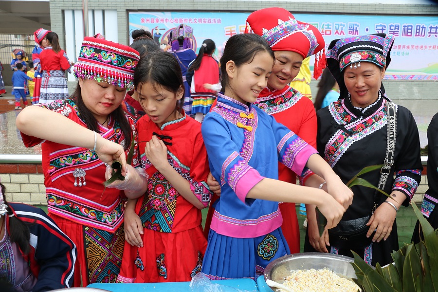 學(xué)生與家長一起體驗包粽子。蒙柳萍攝