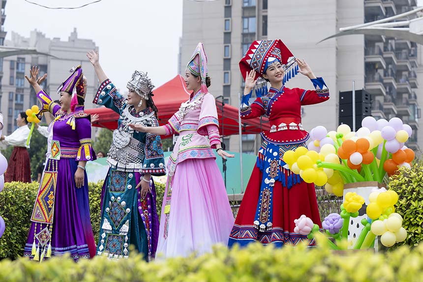 當(dāng)?shù)馗髯逋麄兩碇褡宸b參加活動(dòng)。何華文攝