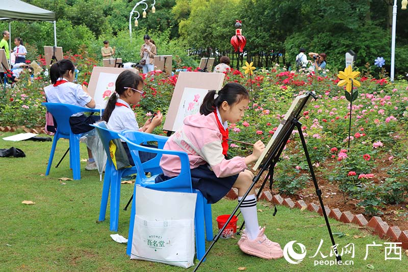 小朋友在花海中寫生。人民網(wǎng) 付華周攝