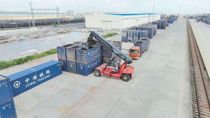 一臺正面吊機(jī)正在進(jìn)行貨物裝卸作業(yè)。何家海攝