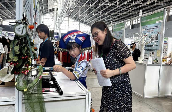 《易看見果柄的高效水果采摘器》發(fā)明人南寧市民主路小學佛子嶺校區(qū)劉妍同學向評委專家介紹作品。南寧市科技館供圖