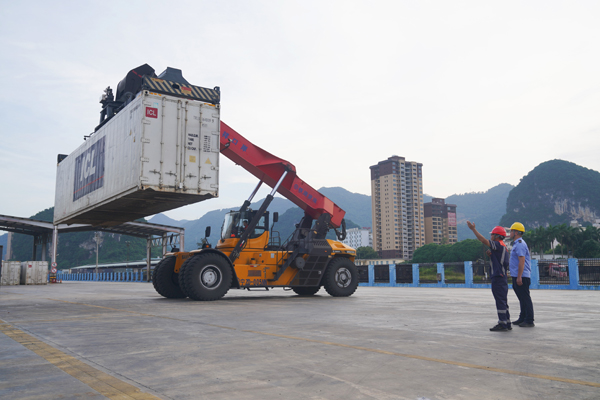 國鐵憑祥口岸物流中心作業(yè)人員指揮正面吊進行吊裝作業(yè)。陳星宇--攝.jpg