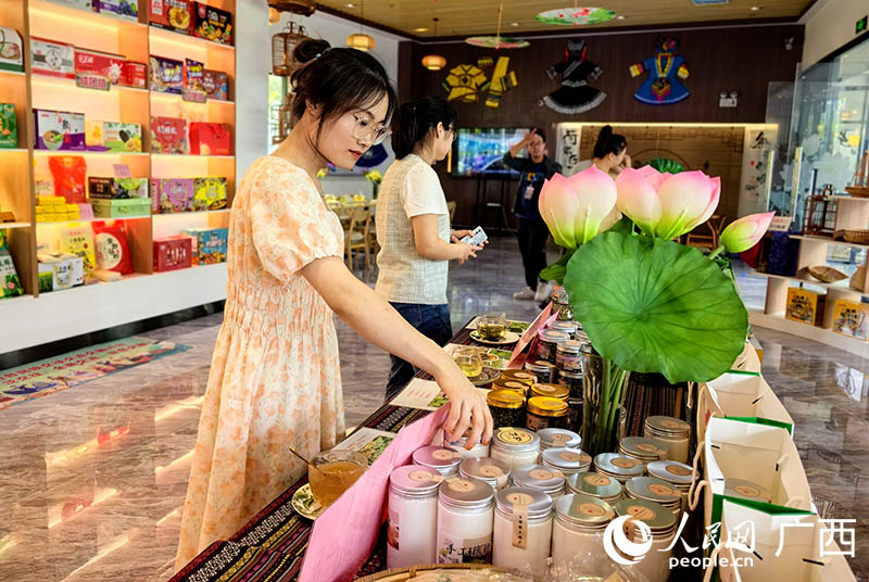 人們在柳江區(qū)荷塘月色現(xiàn)代農(nóng)業(yè)示范區(qū)了解當?shù)剞r(nóng)特產(chǎn)品。人民網(wǎng) 付華周攝