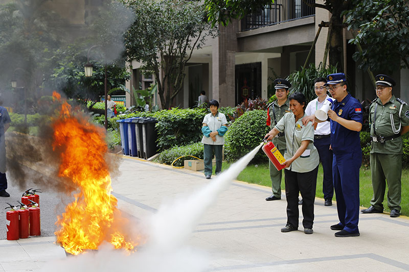 物業(yè)工作人員在指導(dǎo)下用滅火器撲滅火焰。梧州市消防救援支隊供圖