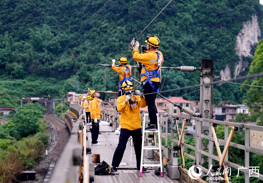 職工在JJC檢修列上對(duì)接觸網(wǎng)設(shè)備進(jìn)行檢查維修。人民網(wǎng)記者 王勇攝