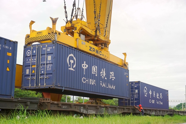 南寧國際鐵路港裝卸作業(yè)人員指揮門吊將集裝箱吊裝上火車。陳星宇攝