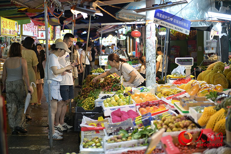 游客在集市里選購(gòu)水果。人民網(wǎng) 雷琦竣攝