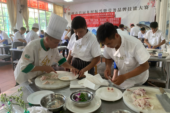 老師向?qū)W生教授刀工技法。