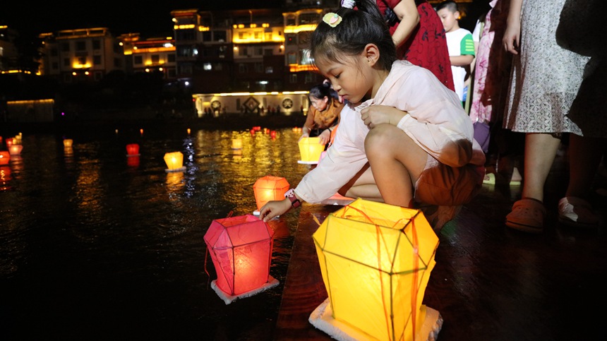 8月16日晚，游客在資江上漂放河燈。