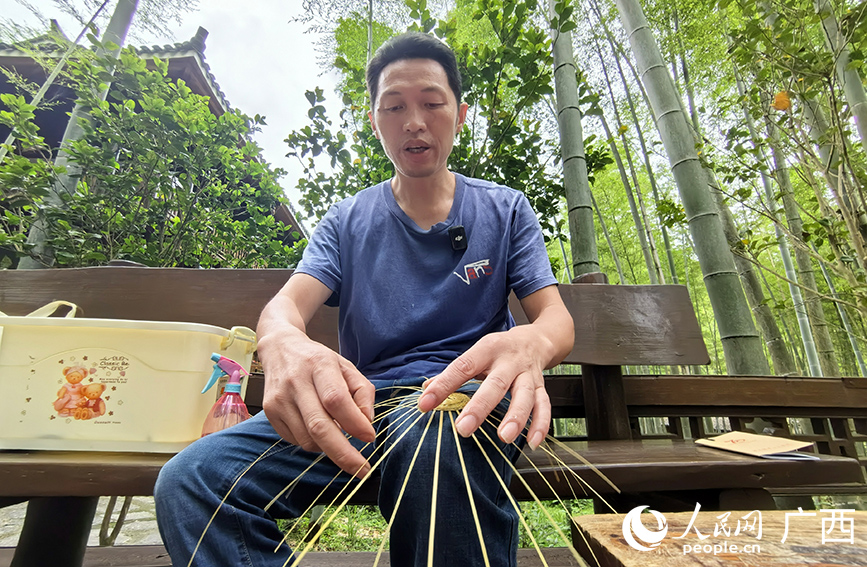 馮文兵在編織的竹工藝品。人民網(wǎng) 付華周攝
