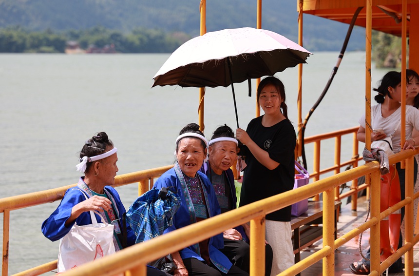身著侗族服飾的老堡鄉(xiāng)村民正在乘坐渡船