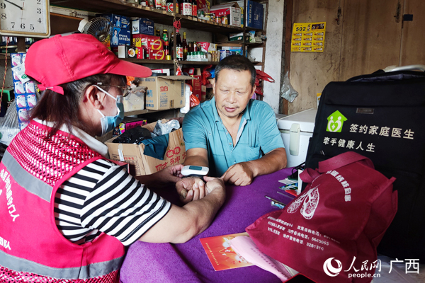 周潤華入戶給群眾檢查身體。人民網(wǎng)記者 王勇攝