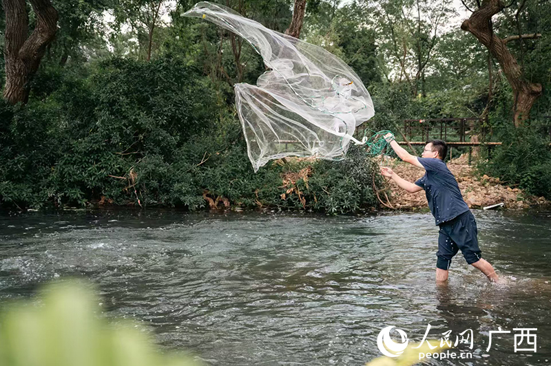 游客在靈渠體驗(yàn)撒網(wǎng)捕魚(yú)。人民網(wǎng)記者 嚴(yán)立政攝