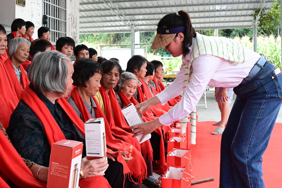 給老年人發(fā)放慰問品。