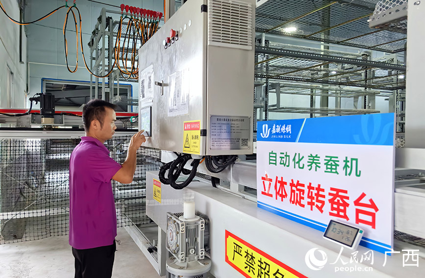 工作人員正在調(diào)試自動化養(yǎng)蠶設備。人民網(wǎng) 付華周攝