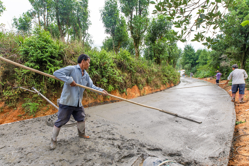 工人正在對路面進(jìn)行攤鋪壓平。