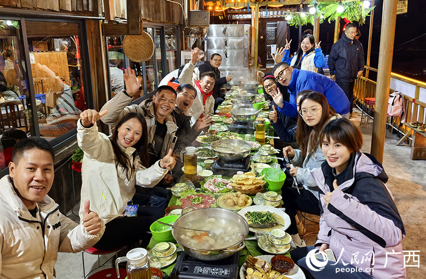 采風團在融水夢嗚苗寨體驗苗家長桌宴。人民網(wǎng) 付華周攝