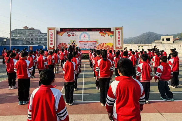 縣底鎮(zhèn)中心學(xué)校委書記覃深甲在國旗下講校史。學(xué)校供圖