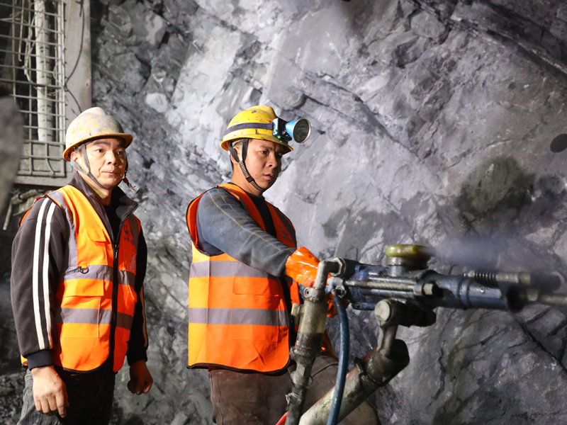 施工人員正在老山隧道進行風(fēng)槍掘進作業(yè)。莫小斌攝