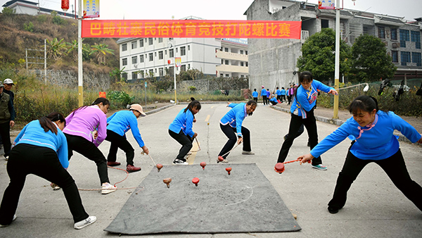 1月23日，廣西東蘭縣巴疇壯寨農(nóng)耕文化旅游節(jié)村民一起打陀螺。高東風(fēng)攝