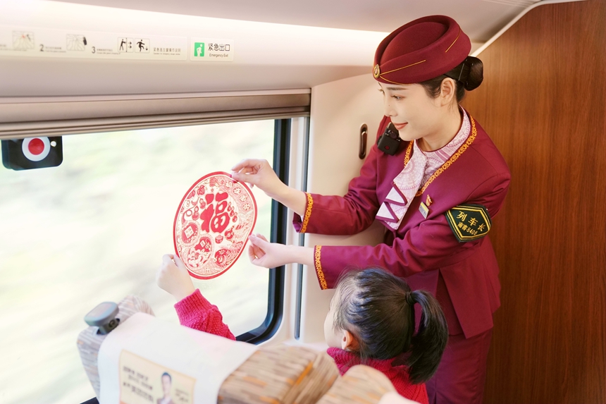 列車長(zhǎng)與小朋友一起貼窗花 。曹爍攝