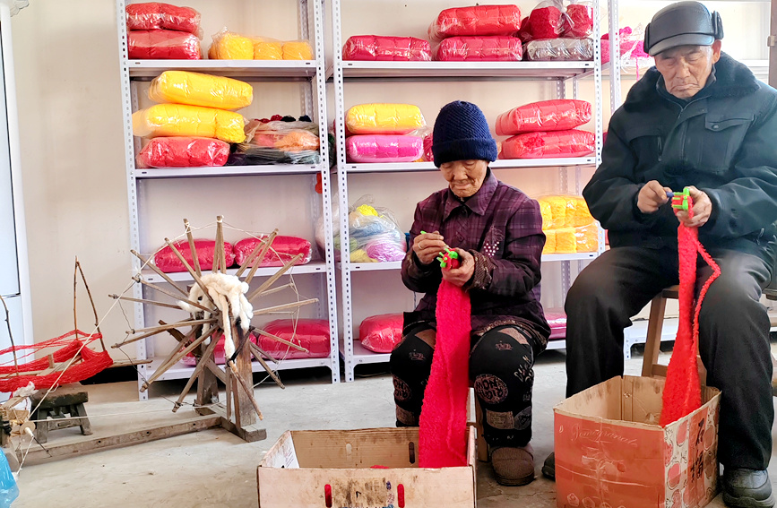 趙中福和張娥梅在織圍巾。