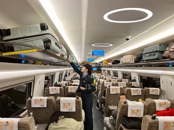 列車長黃小洋正在整理車廂行李架。舒鵬攝