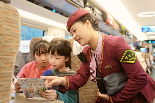 列車長楊亞楠向乘車的孩子提供繪本讀物。曹爍攝