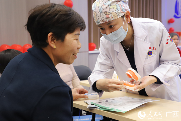 醫(yī)護(hù)人員教市民如何清潔與保護(hù)牙齒。人民網(wǎng)記者 王勇攝