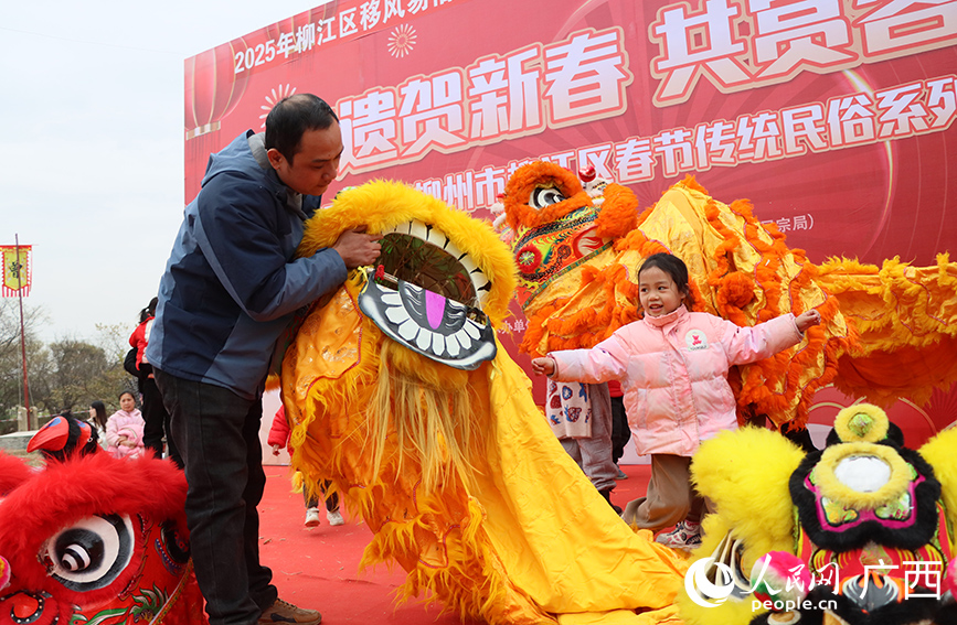 大人引導(dǎo)小孩體驗舞彩獅。人民網(wǎng) 付華周攝