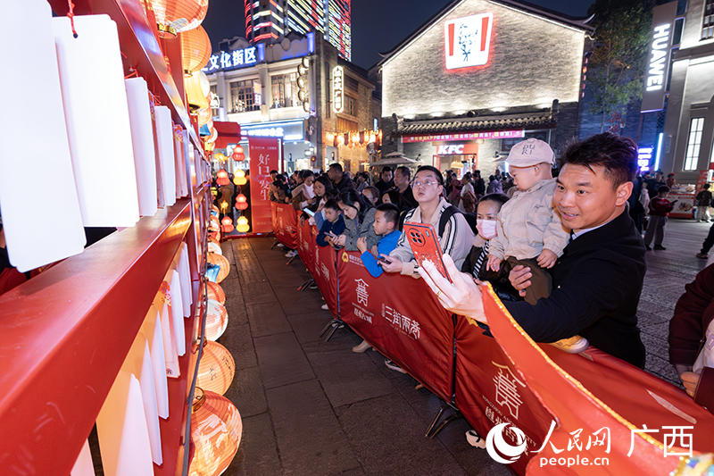 家長帶著孩子在猜燈謎。人民網(wǎng) 雷琦竣攝