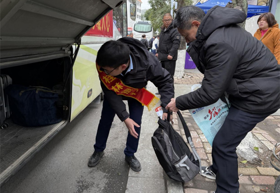協(xié)助返崗人員搬運行李。易孟鑫攝