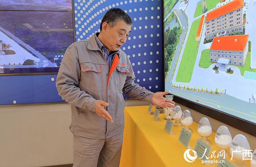 廣西興業(yè)時泰納米科技公司相關負責人介紹企業(yè)生產的相關碳酸鈣產品。人民網 付華周攝