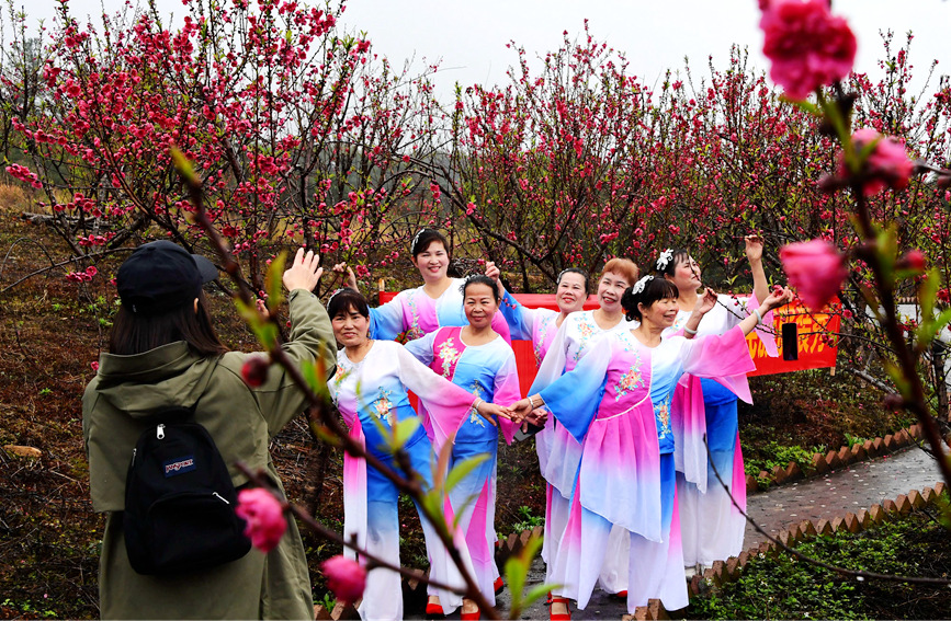 游客在羅城天河鎮(zhèn)彩虹谷桃花島內(nèi)留影。