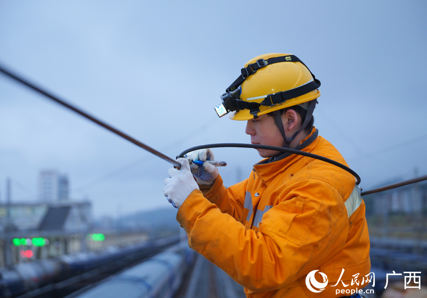 接觸網(wǎng)工正在對(duì)檢修過后的百色普速場接觸網(wǎng)設(shè)備進(jìn)行畫線標(biāo)記。人民網(wǎng)記者 王勇攝