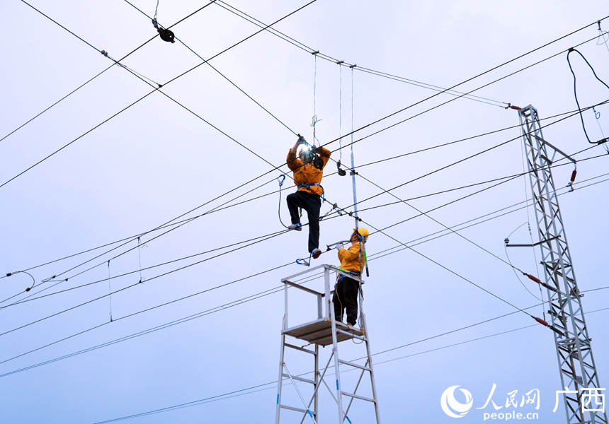 接觸網(wǎng)工正在使用人工車梯對百色普速場的接觸網(wǎng)設(shè)備進(jìn)行檢修。人民網(wǎng)記者 王勇攝