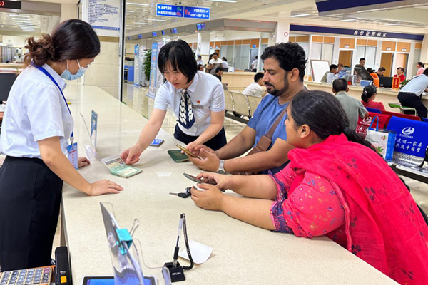 政務(wù)服務(wù)語(yǔ)言無(wú)障礙服務(wù)專(zhuān)班在指導(dǎo)外籍人士辦理業(yè)務(wù)。曾菊花攝