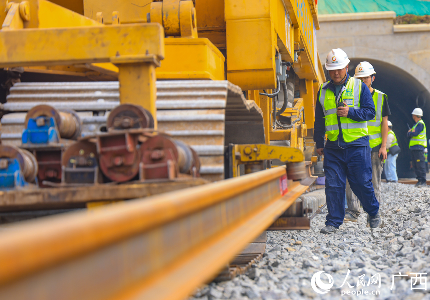 施工人員在盯控鋪軌機(jī)作業(yè)。人民網(wǎng)記者 王勇攝