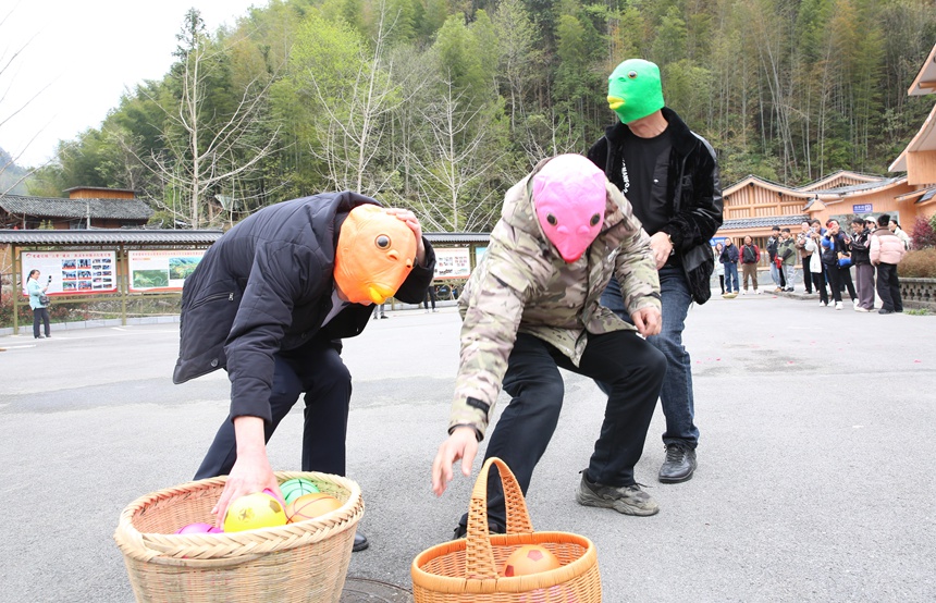 游客們?cè)谲囂锩缱遴l(xiāng)石山底參加游園活動(dòng)。